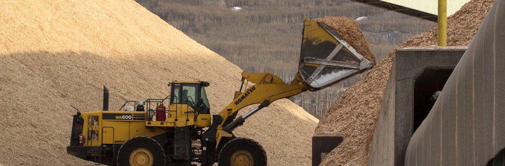 Front loader carrying hardwood chips to a chip pile at the Mercer Peace River pulp mill near Peace River, Alberta, Canada