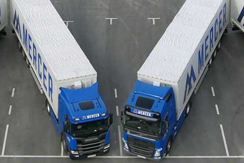 Mercer Holz trucks parked in the parking lot of the Mercer Rosenthal pulp mill, forming the Mercer "M"