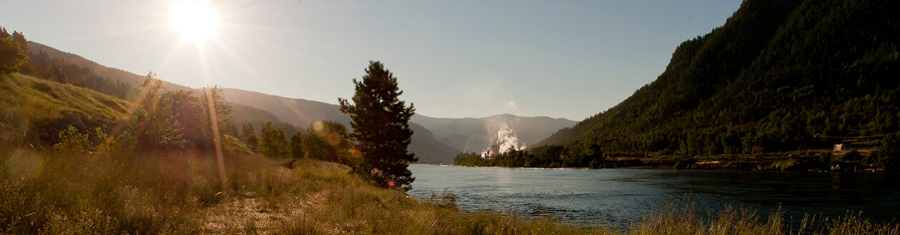 Celgar pulp mill seen in the distance along the Nelson River, British Columbia, Canada, at sunrise