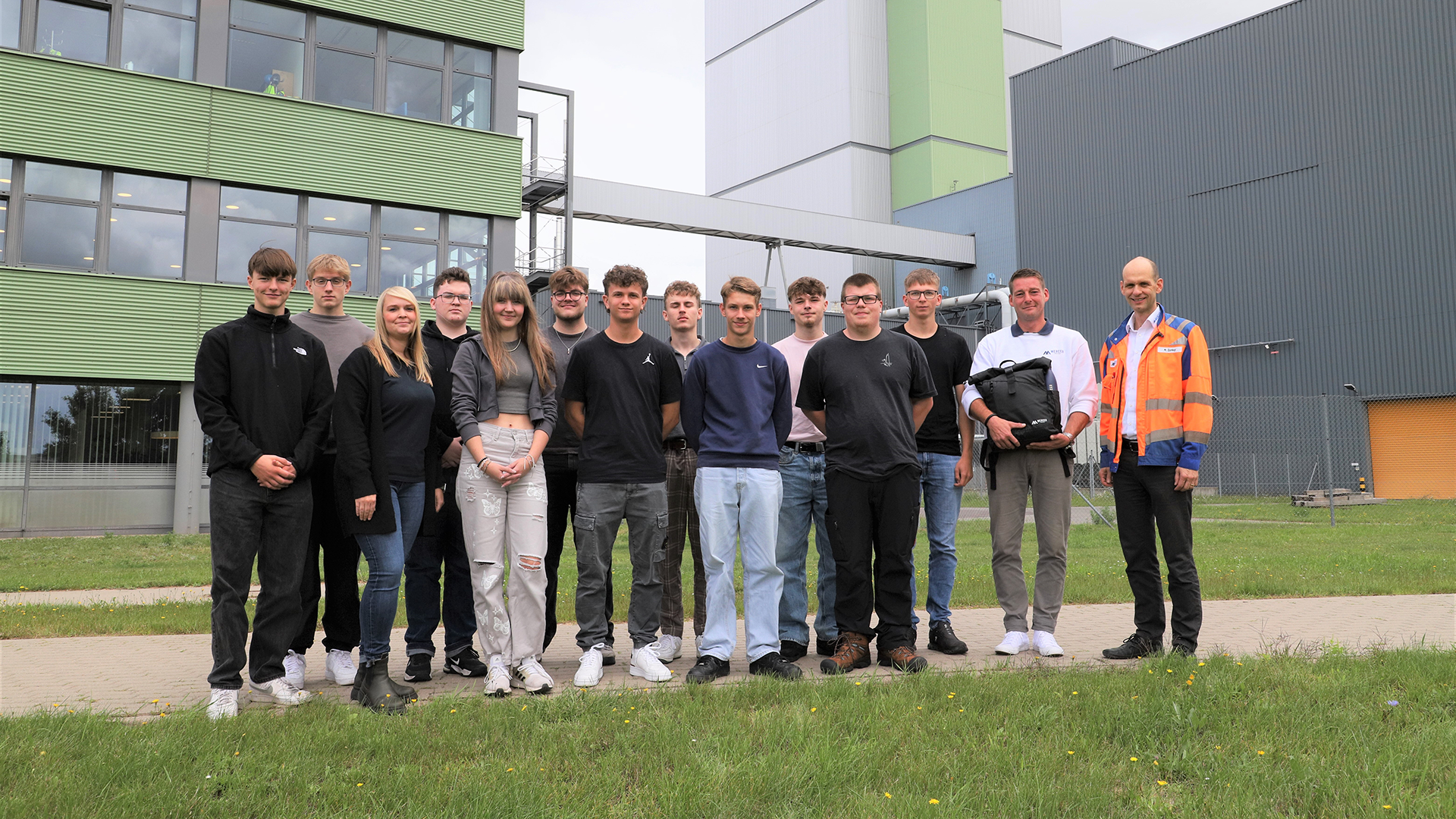 A group of young people stands in front of the Mercer Stendal pulp mill.
