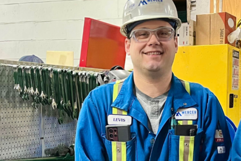 Levis Fortin and Dustin Thompson stand smiling in front of a tool bench. Dustin Thompson, Maintenance Technician, supported through electrical and instrumentation trade tickets.